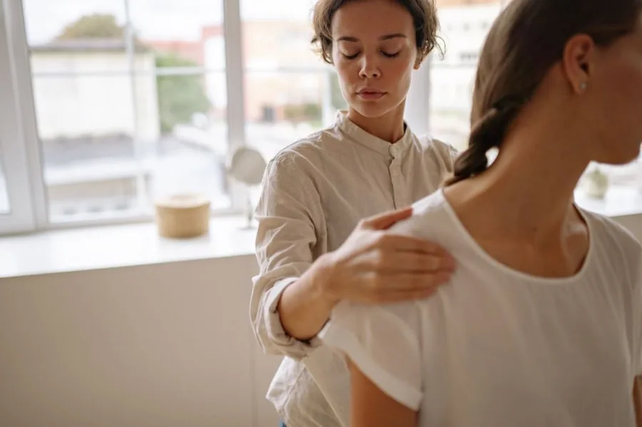 Physiotherapist performing a hands-on shoulder assessment at Matrix Rehab